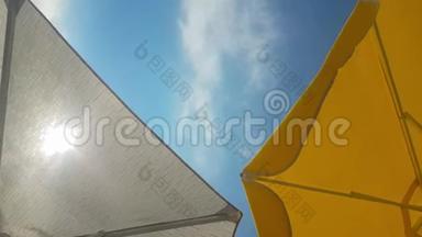 夏日的沙滩伞迎着太阳和蓝天..